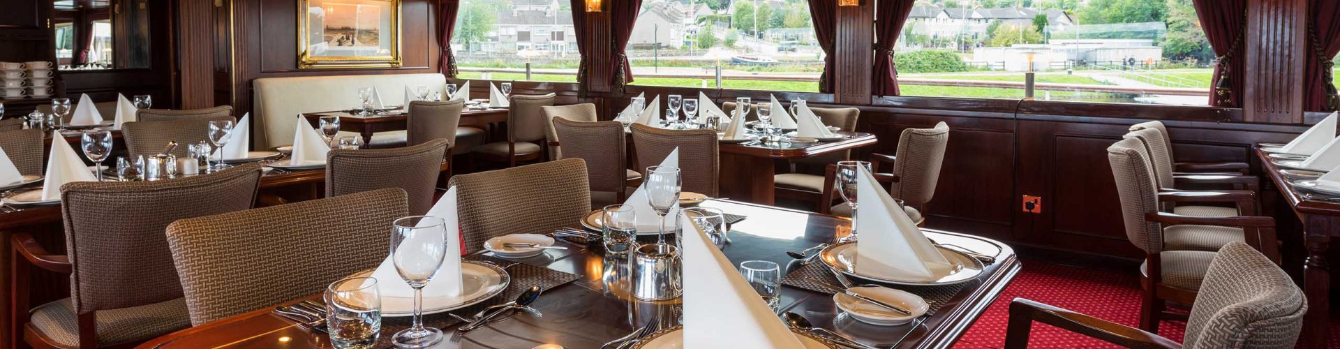 Tables set for dining in the Robert Louis Stevenson Restaurant on the Alexander Graham Bell deck on Lord of the Glens cruise ship